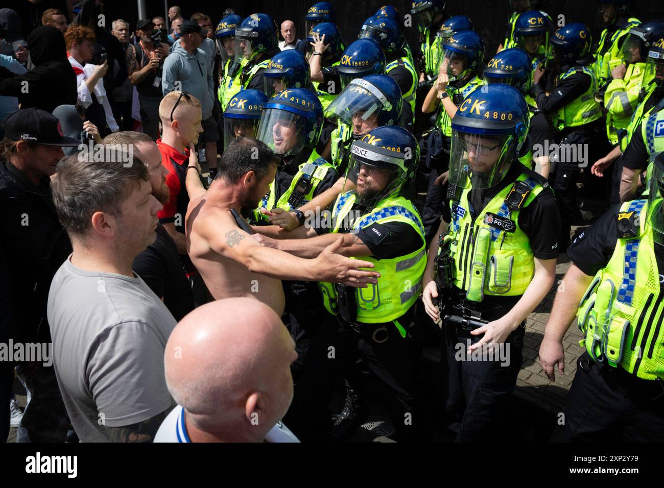 Manchester, UK. 03rd Aug, 2024. A anti-immigration supporter confronts riot police after scuffles broke out in Piccadilly Gardens. Earlier this week, protests and riots erupted across the country after a horrific knife attack in Southport, which saw a 17-year-old boy kill three innocent young children. Misinformation about the attacker spread across social media, reporting that he was an asylum seeker, which was later proved to be incorrect.ÊAndy Barton/Alamy Live News Credit: Andy Barton/Alamy Live News Stock Photo