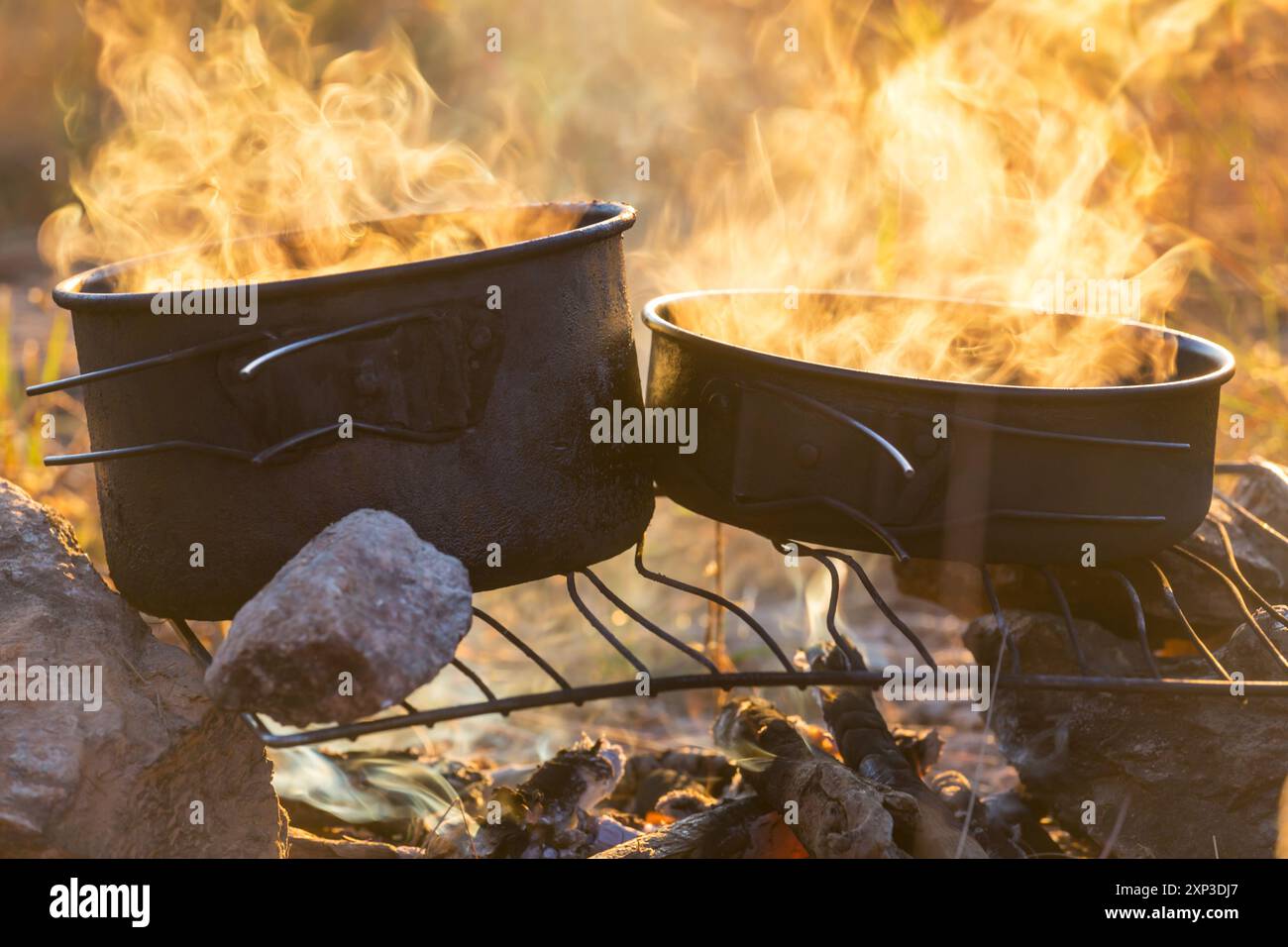 Touristic kettle on fire of burning campfire in camping in the hike ...