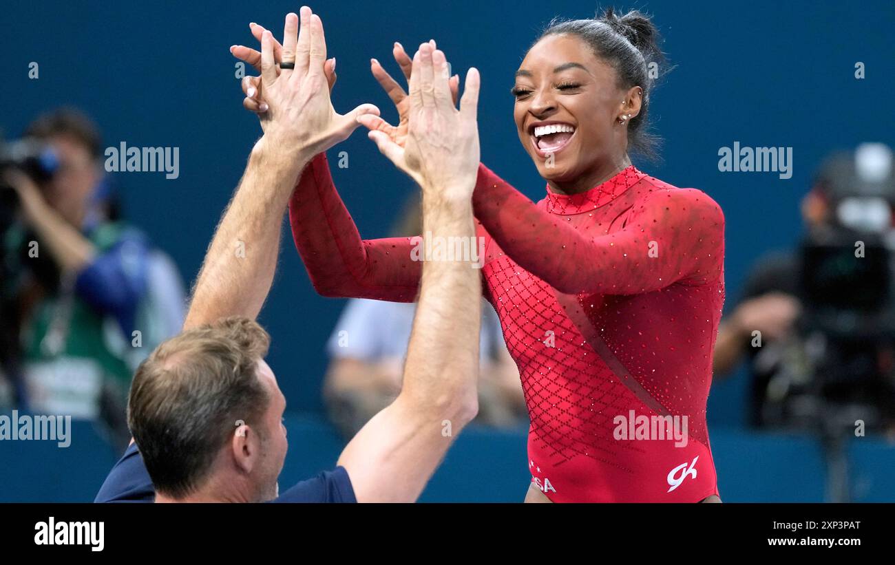 Simone Biles, of the United States, is congratulated after competing ...