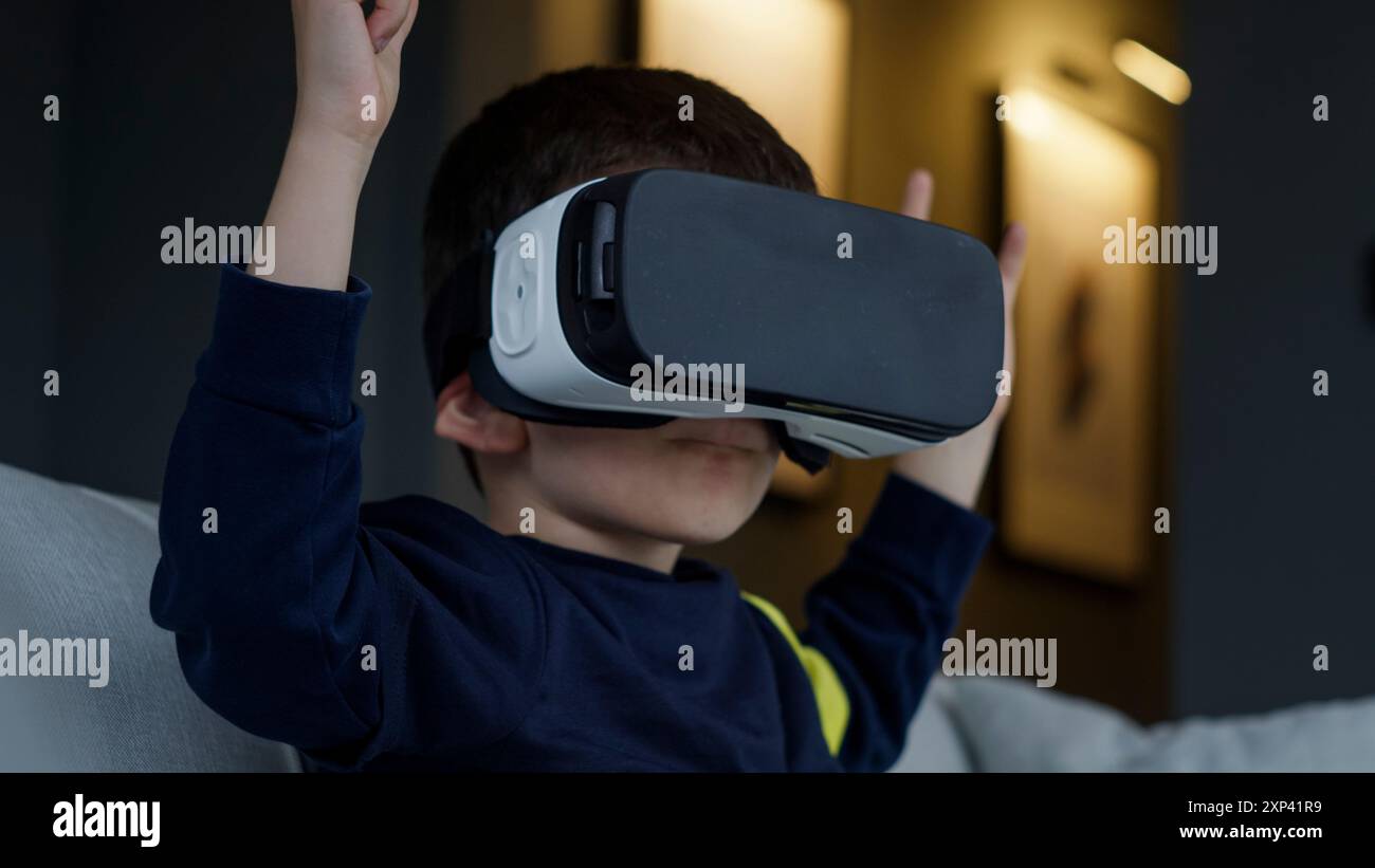 A young boy exploring virtual reality with a VR headset. The ...