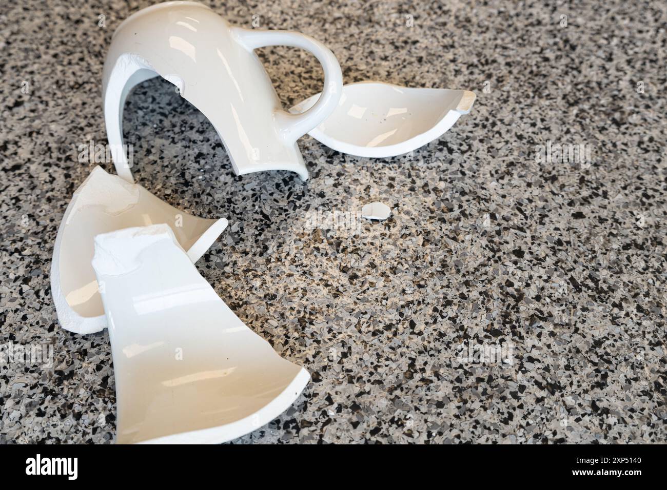 Smashed dropped coffee mug on floor in pieces Stock Photo