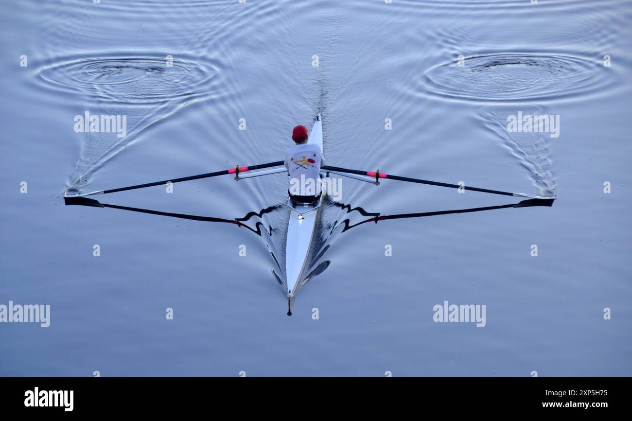 Single scull rower in the calm, early morning water on the River ...
