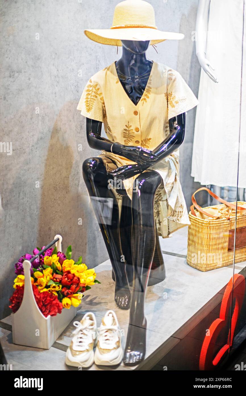 female African mannequin in a summer hat and dress in a supermarket window Stock Photo