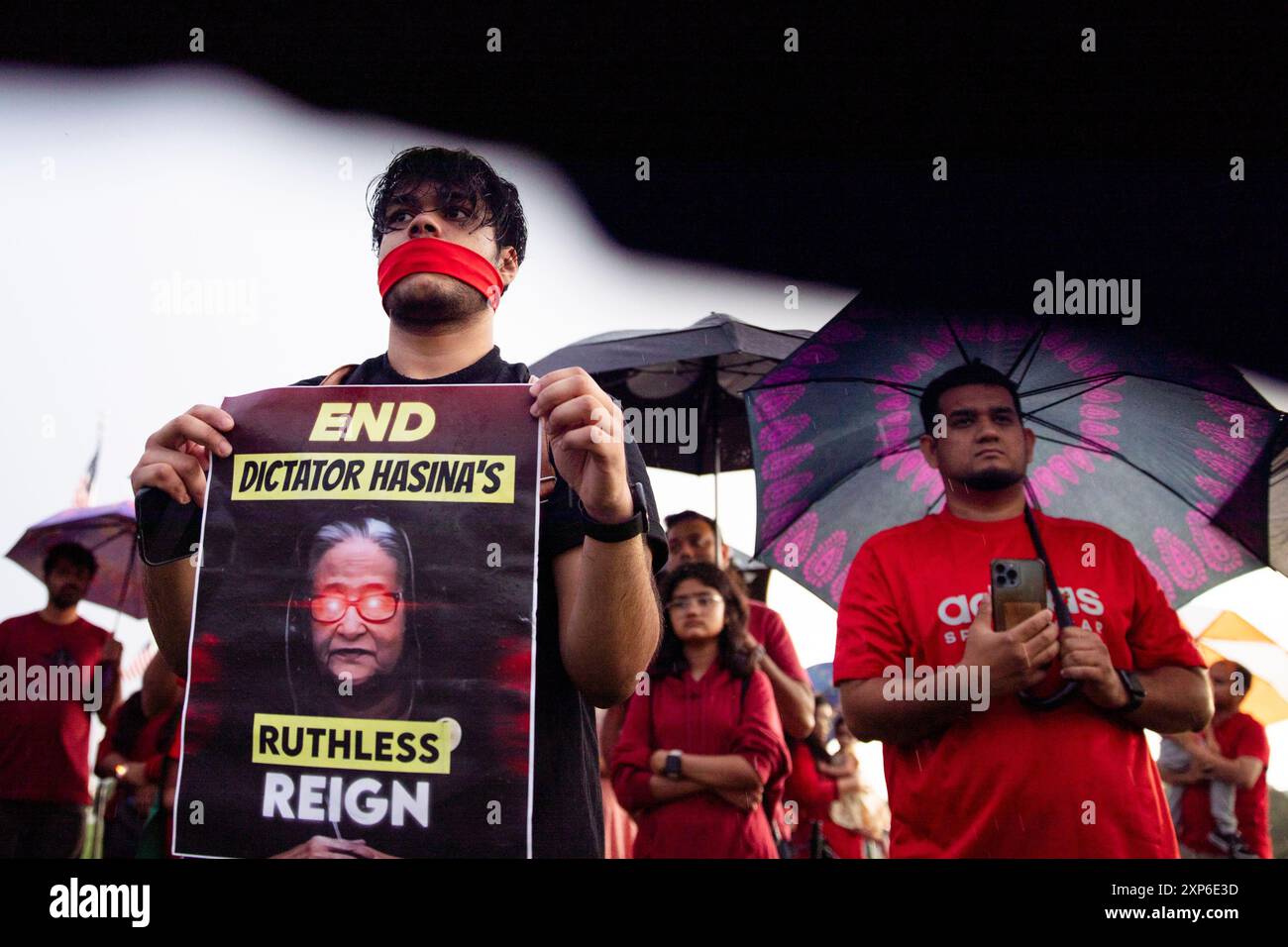 Washington DC, USA. 3rd Aug 2024. An attendee ties a red cloth on his mouth and holds a sign while attending a candlelight vigil on August 03, 2024, in the National Mall, Washington DC, USA to support the Anti-Discriminatory Students Movement in Bangladesh. In the vigil, participants condemned the government for killing innocent and underage students. They also demand to step down current prime minister Sheikh Hasina, who has been in power since 2009.  But later protests began in bloodshed, and more than 250 people were killed. Credit Credit: Aashish Kiphayet/Alamy Live News Stock Photo