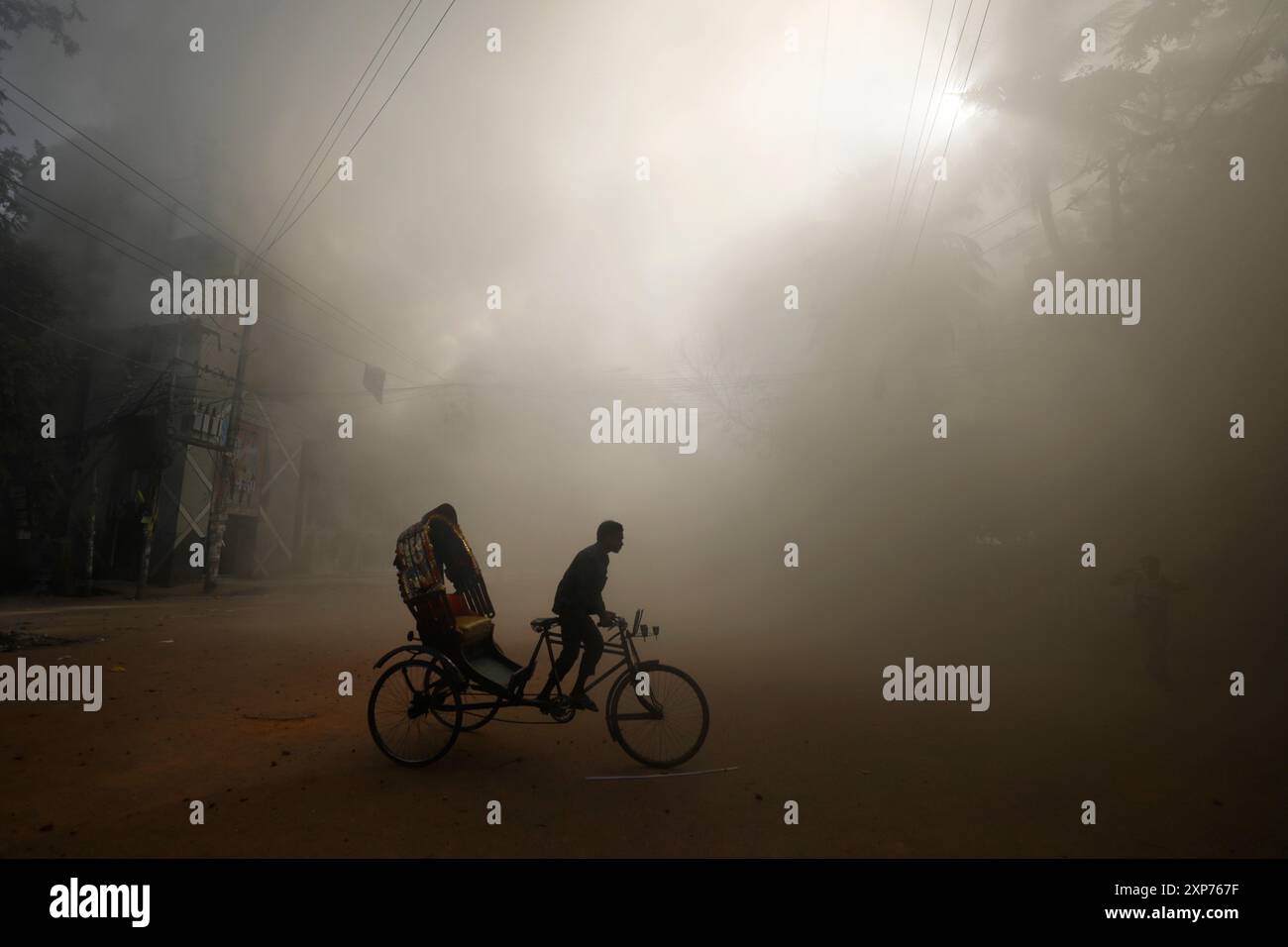 Fire Rickshaw A rickshaw puller rides in the smoke caused by a burning shopping ...