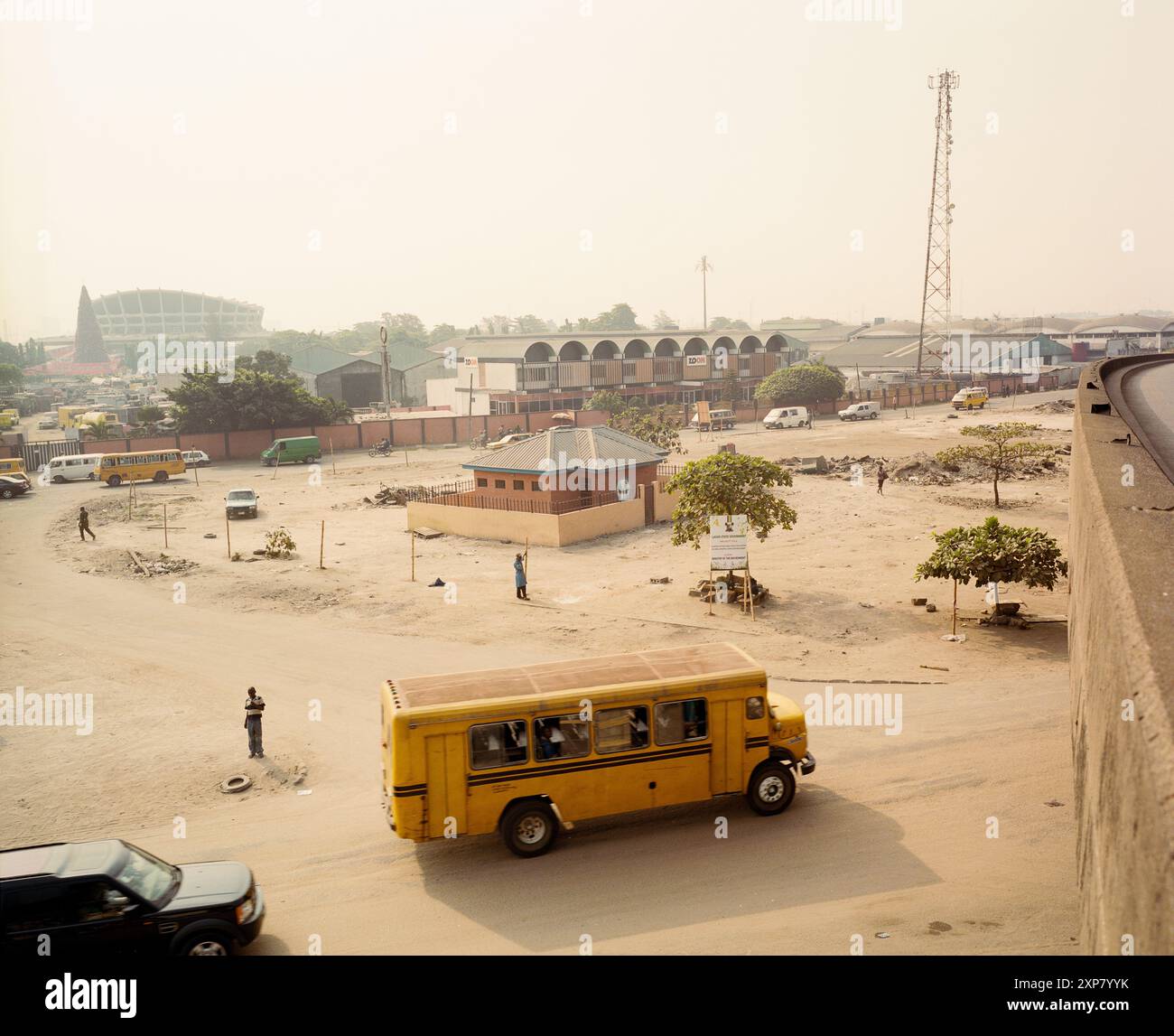 An image depicting a public toilet as part of a landscaping project along the Apapa-Ijora Expressway in Lagos, Nigeria. The scene shows bustling street life, modern structures, and local transport, symbolizing urban development and public sanitation. 2009 Stock Photo