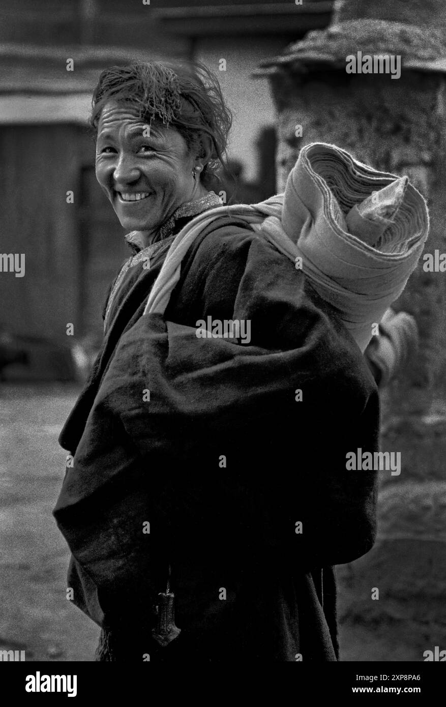 A Tibetan man with bed roll makes a  pilgrimage to  Drepung Monastery in Lhasa Tibet - 1986 Stock Photo