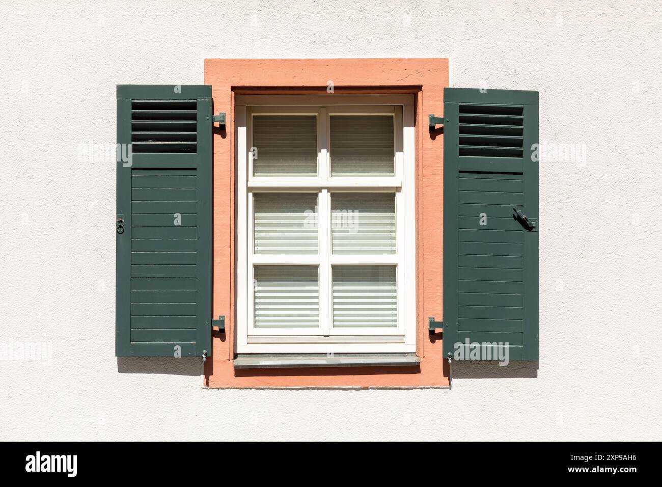 background of old historic window with closed shutters and sandstone window sills and green window shutters Stock Photo