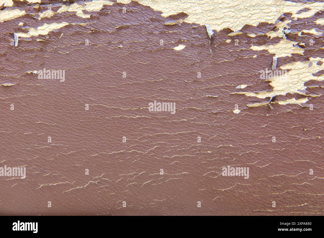 Close-up of peeling paint on cracked leather surface. Textured background for design and print. Stock Photo