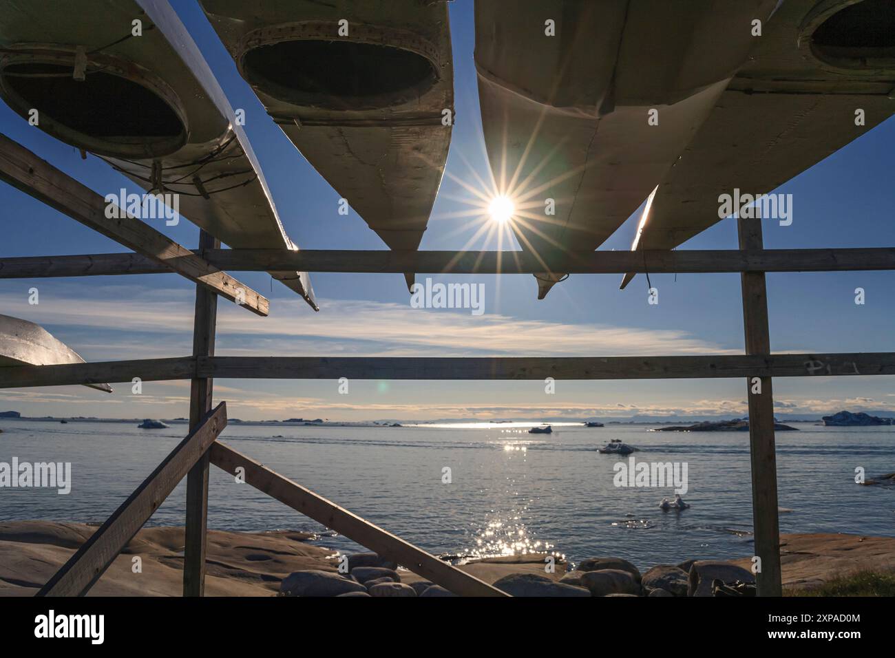 Traditional kayaks of Inuit people on a rack, Ilulissat, Disko Bay, Greenland Stock Photo