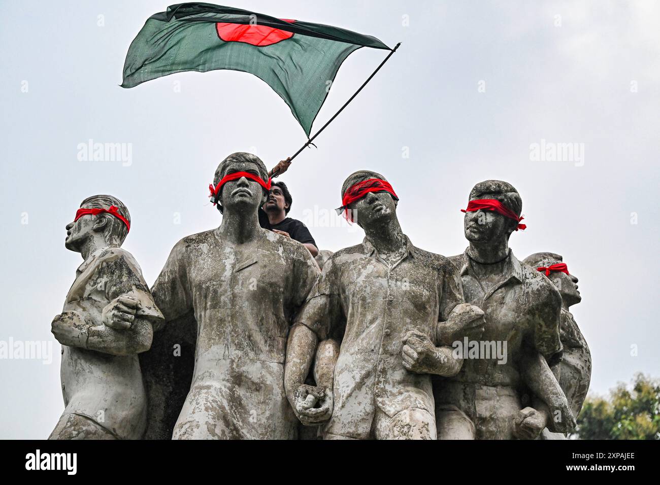 Bangladeshi student is waving flag above Raju Memorial Sculpture during ...