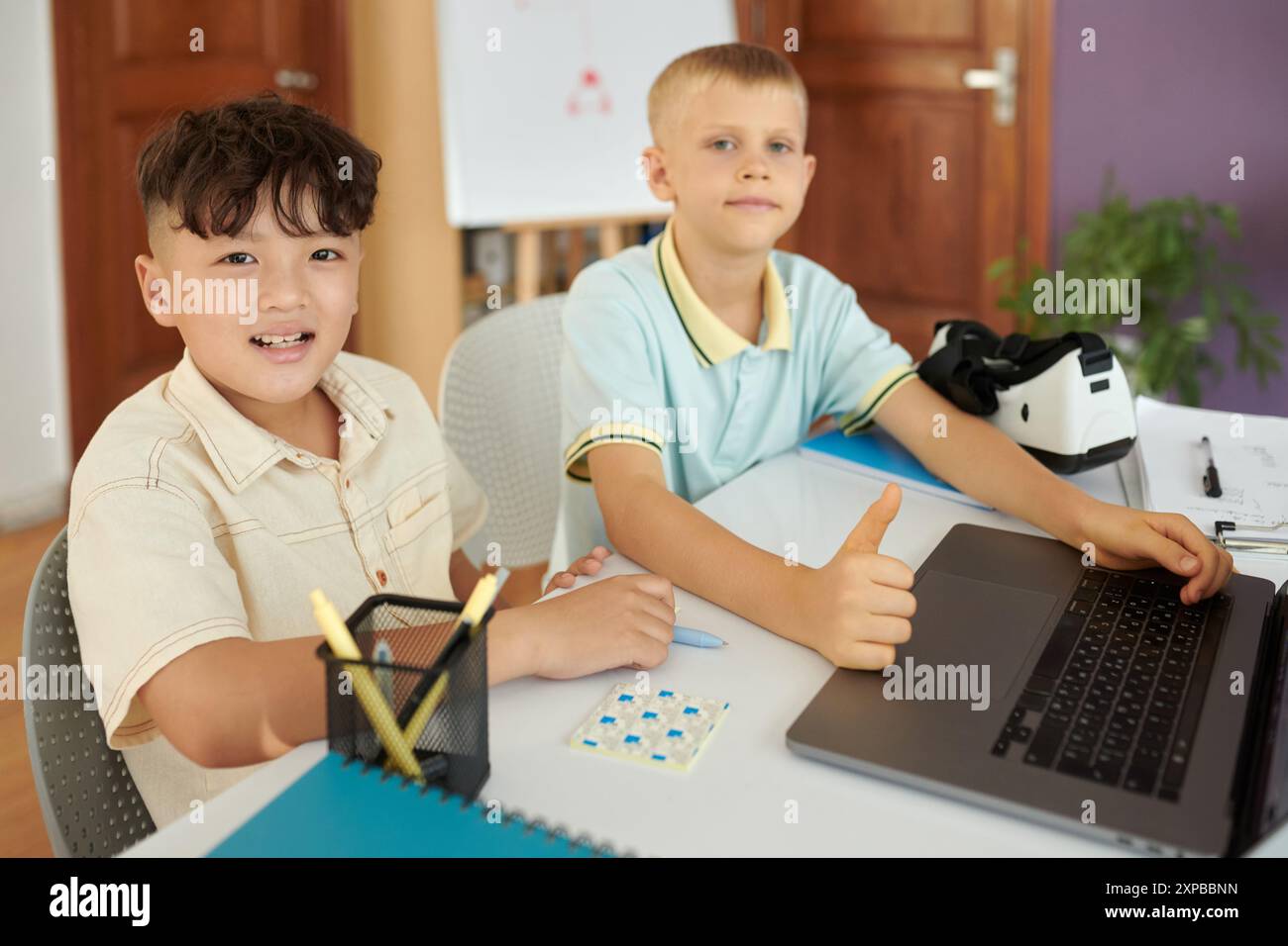 Smiling Boys Working Together on Digital Project Stock Photo
