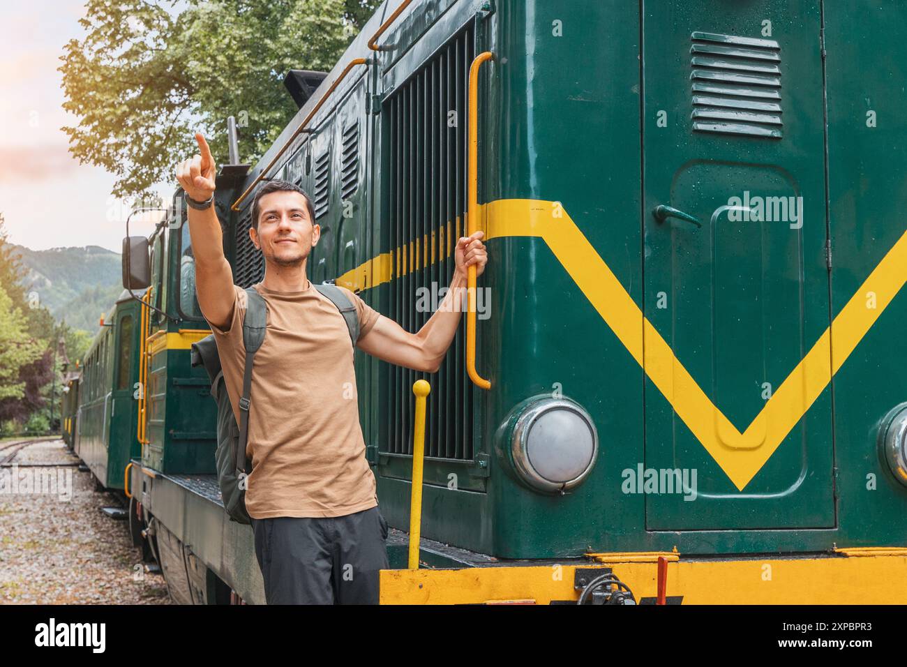 A tourist smiling as they board a vintage train at the platform, ready ...