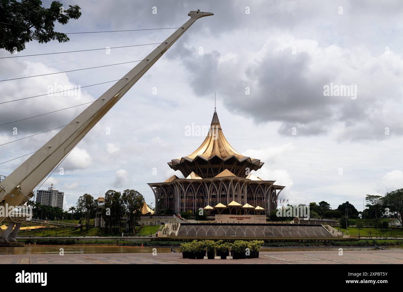 Pylon from the Darul hana bridge with the Bangunan Dewan Undangan State assembly building behind, Sarawak River, Kuching, Malaysia Stock Photo