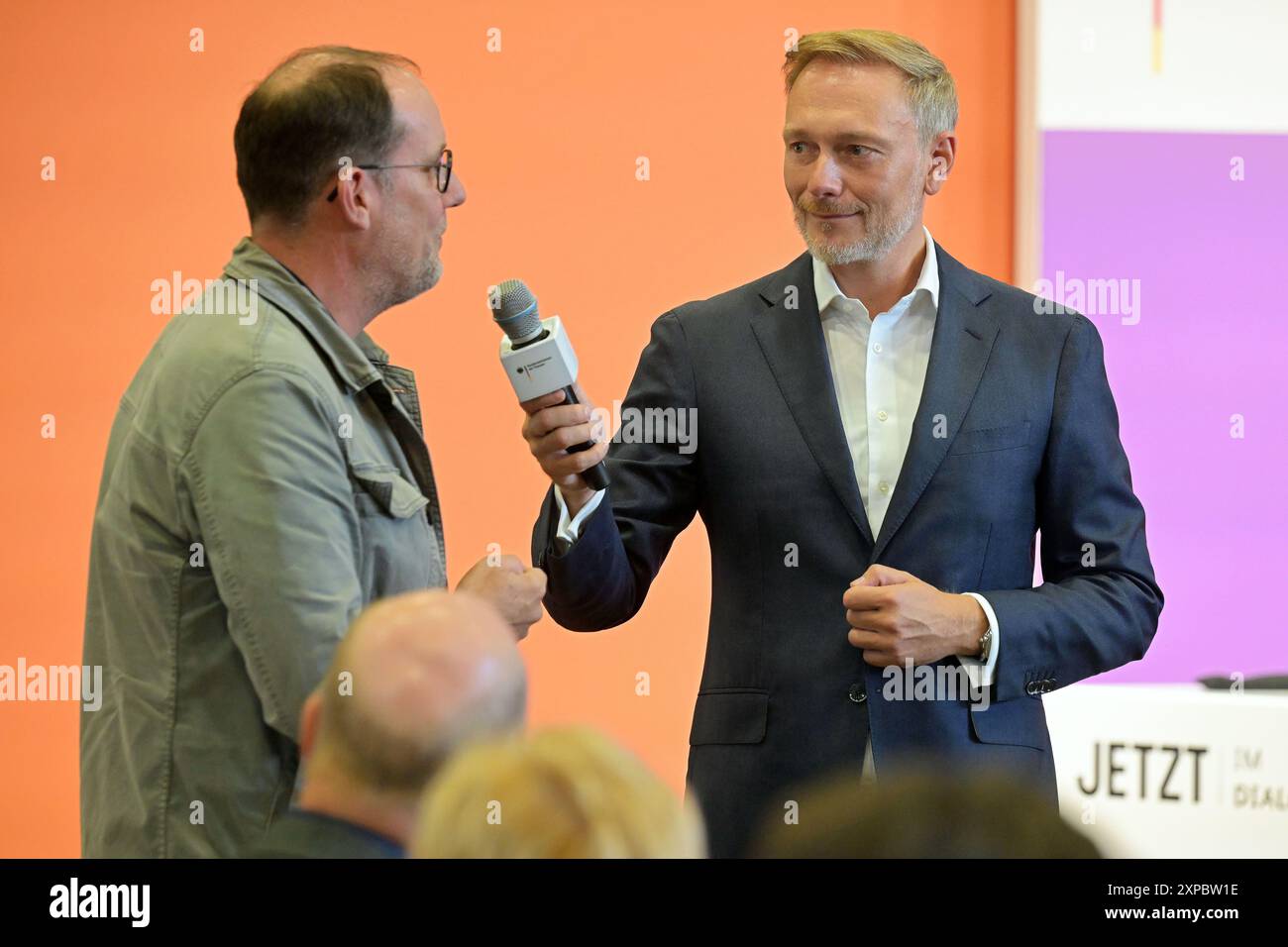 Potsdam, Germany. 05th Aug, 2024. Federal Finance Minister Christian Lindner (FDP) holds the microphone for a questioner. The minister talks to employees from the trades, retail, schools and companies. Credit: Michael Bahlo/dpa/Alamy Live News Stock Photo