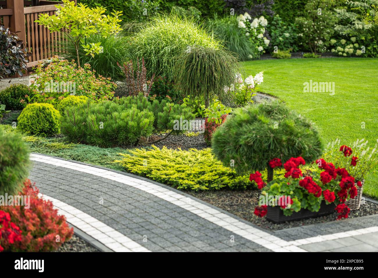 A vibrant garden features neatly arranged flower beds, diverse greenery ...