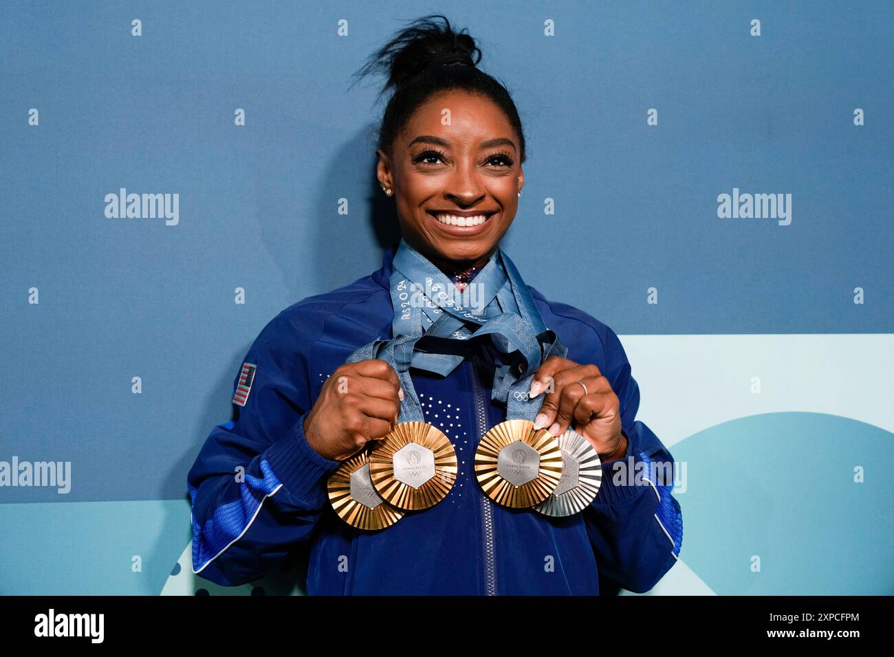 Simone Biles, of the United States, holds up her medals after the women ...
