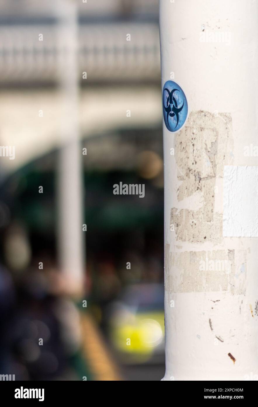 Biohazard sticker on white pole outside Edinburgh Waverly train station Stock Photo