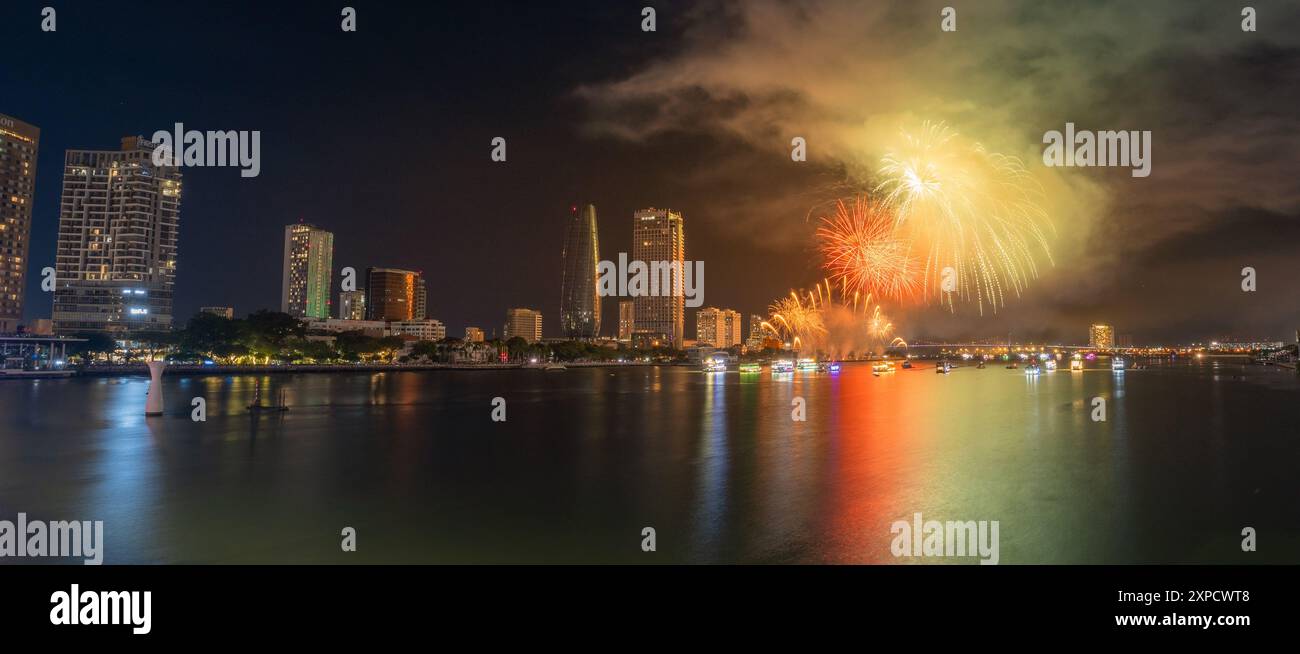 Da Nang city, Vietnam - 13 Jul 2024: Skyline with fireworks light up sky over Han river in Da Nang City, Vietnam. Beautiful night view cityscape. Holi Stock Photo