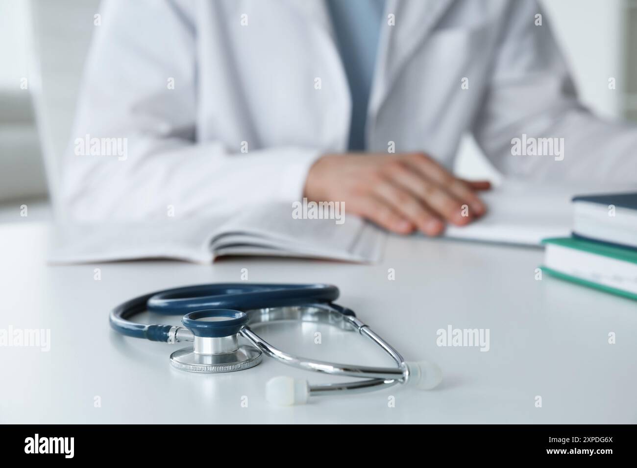 Doctor at white table in hospital, focus on medical stethoscope Stock ...