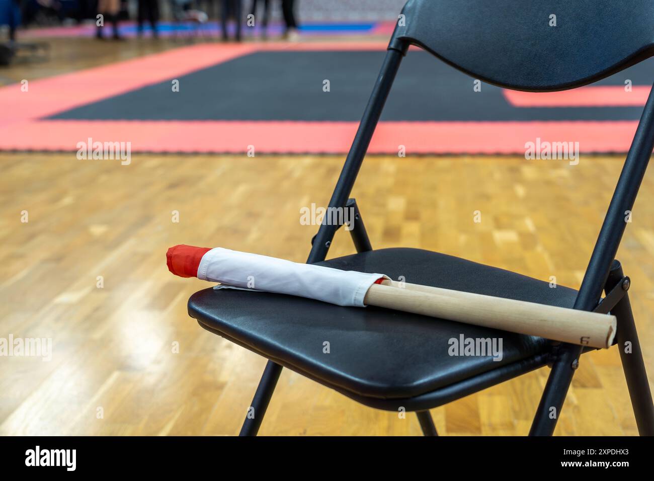 The referee's red and white flags are waiting for the referee on the chairs. The concept of the Kyokushin karate competition. Stock Photo