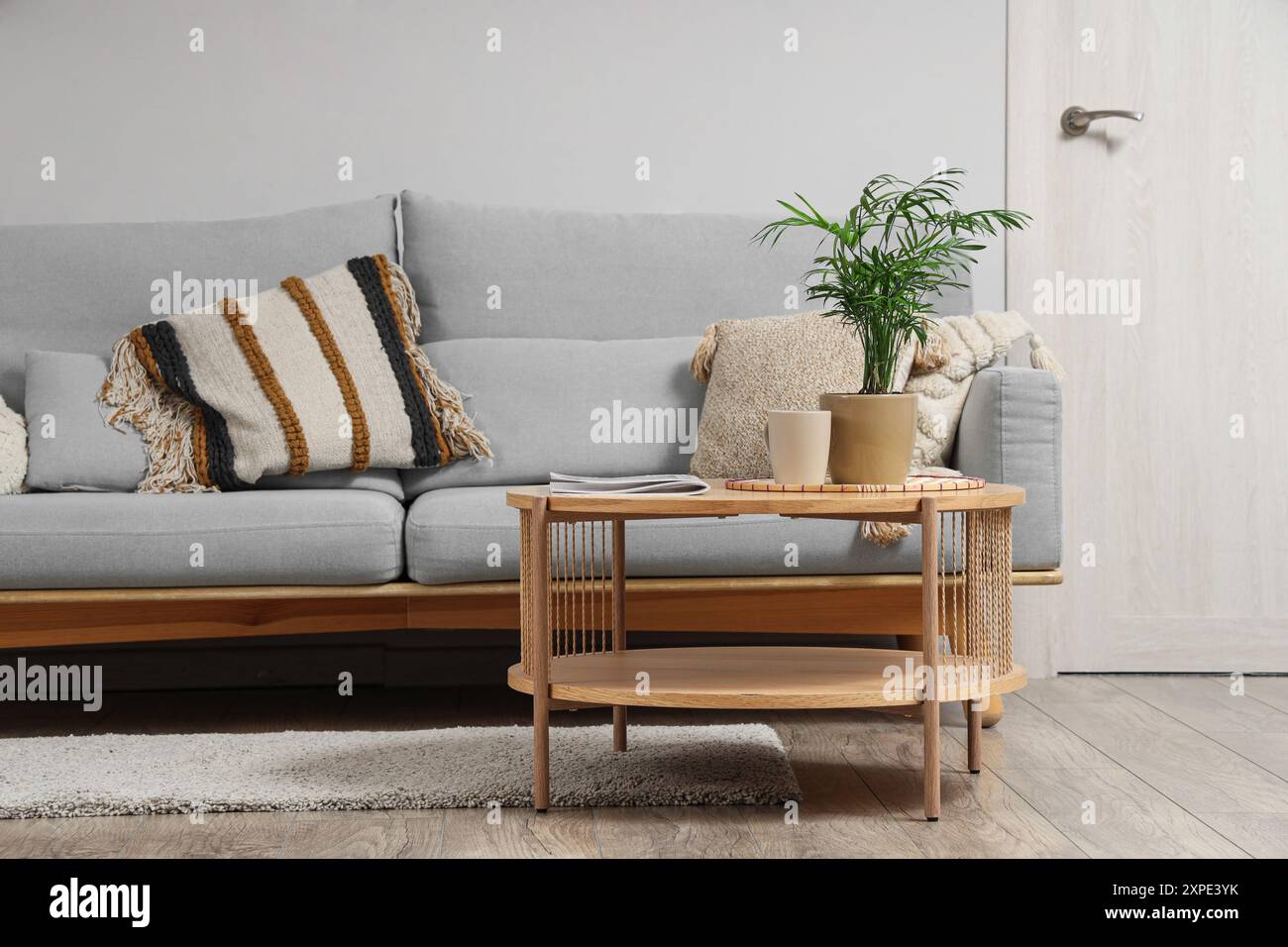 Interior of light living room with grey sofa and table Stock Photo - Alamy