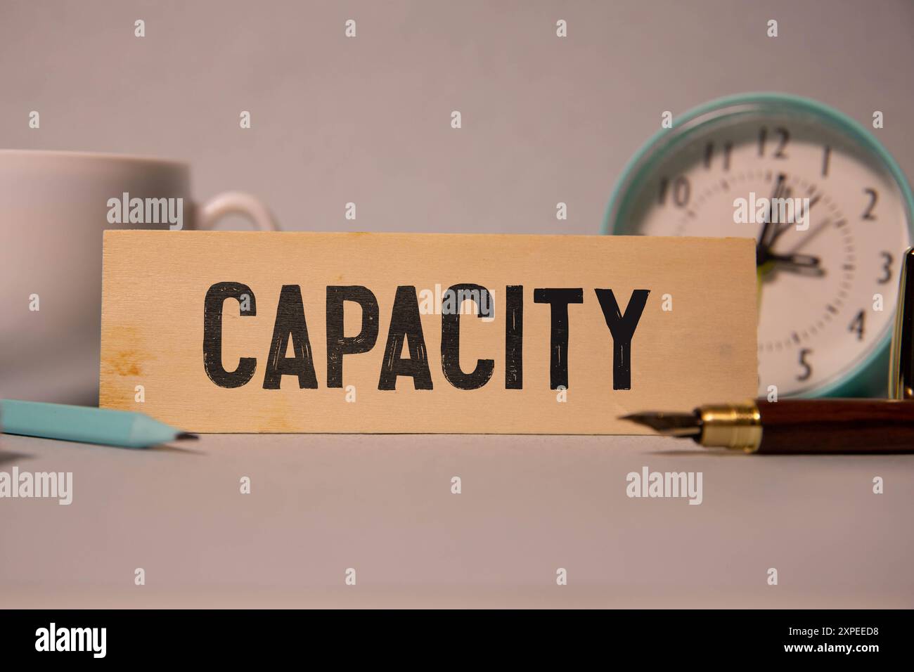 CAPACITY text on a strip of wood lying on a white table. Concept Stock ...