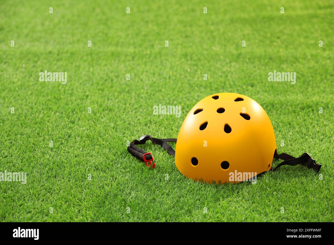 Yellow protective helmet on green grass, space for text Stock Photo - Alamy