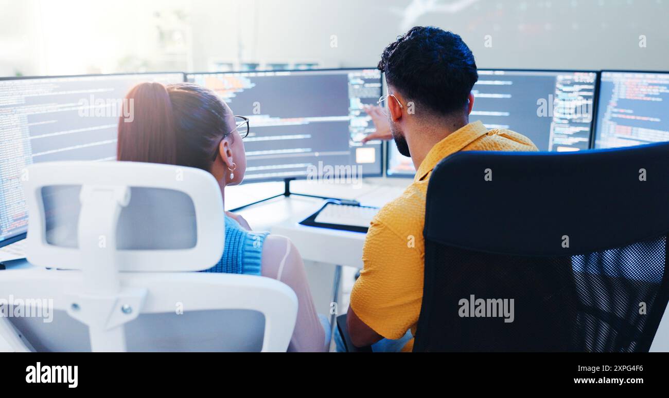 Back, team and computer screen in office for code, web development and software programming. Man, woman and developers in talk for cybersecurity Stock Photo