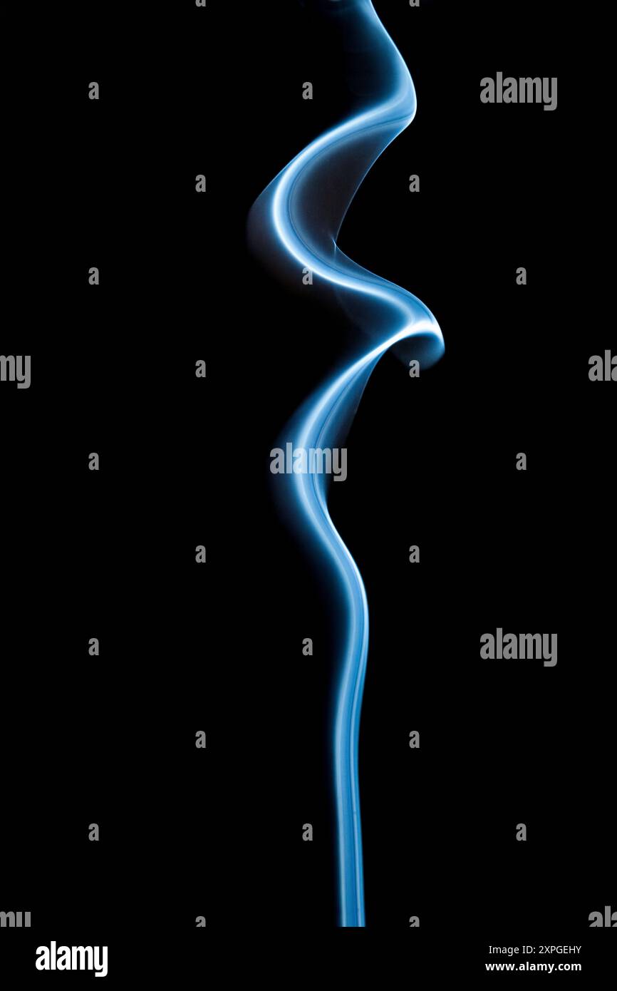 Smoke rising from an incense stick - studio picture against a black background Stock Photo