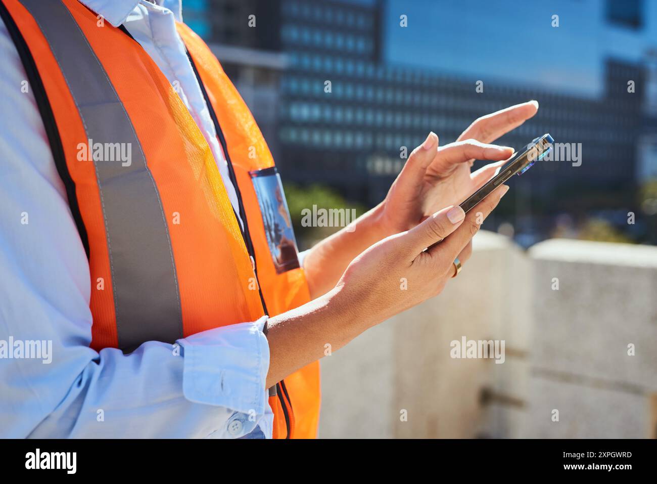 Construction Worker Using Smartphone at Urban Construction Site Stock Photo