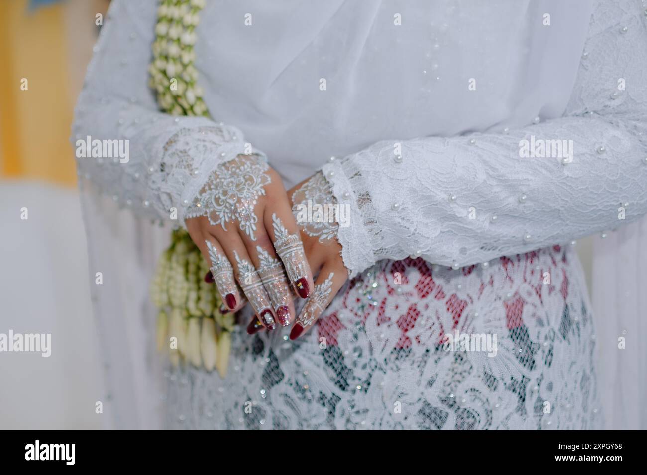 the bride's hands with traditional henna and red nail polish and charming accessories Stock Photo