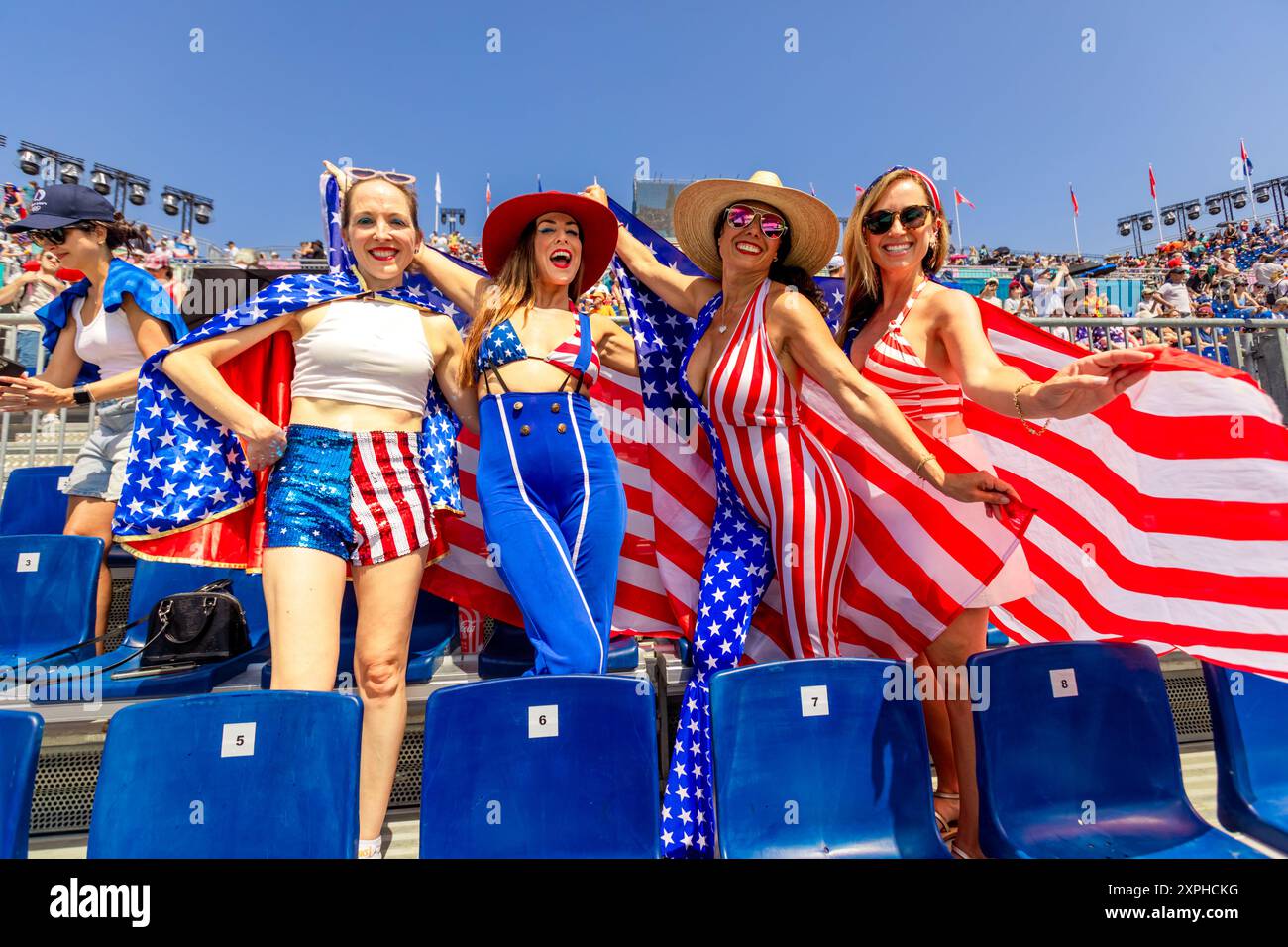 Patriotic American Woman jumping and cheering for Team USA and the Paris 2024 Olympics in front of the Eiffel Tower, Paris, France, Europe Stock Photo