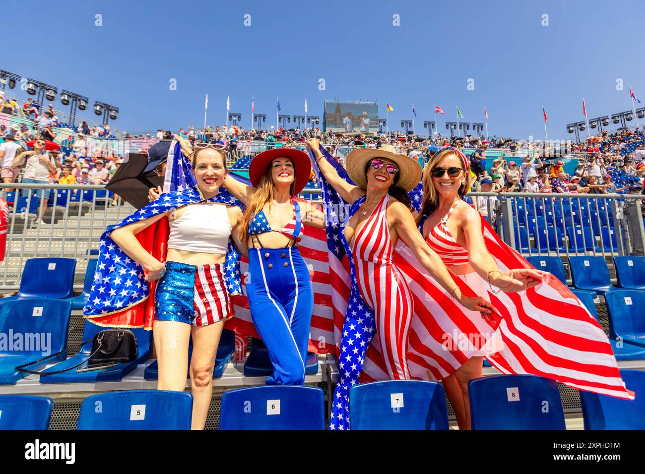 Patriotic American Woman jumping and cheering for Team USA and the Paris 2024 Olympics in front of the Eiffel Tower, Paris, France, Europe Copyright: Stock Photo