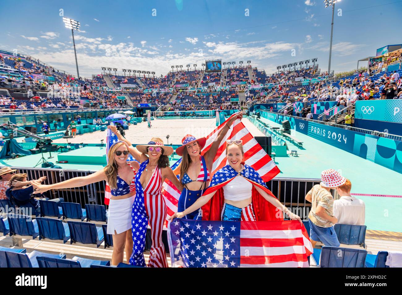 Patriotic American Woman jumping and cheering for Team USA and the Paris 2024 Olympics in front of the Eiffel Tower, Paris, France, Europe Copyright: Stock Photo