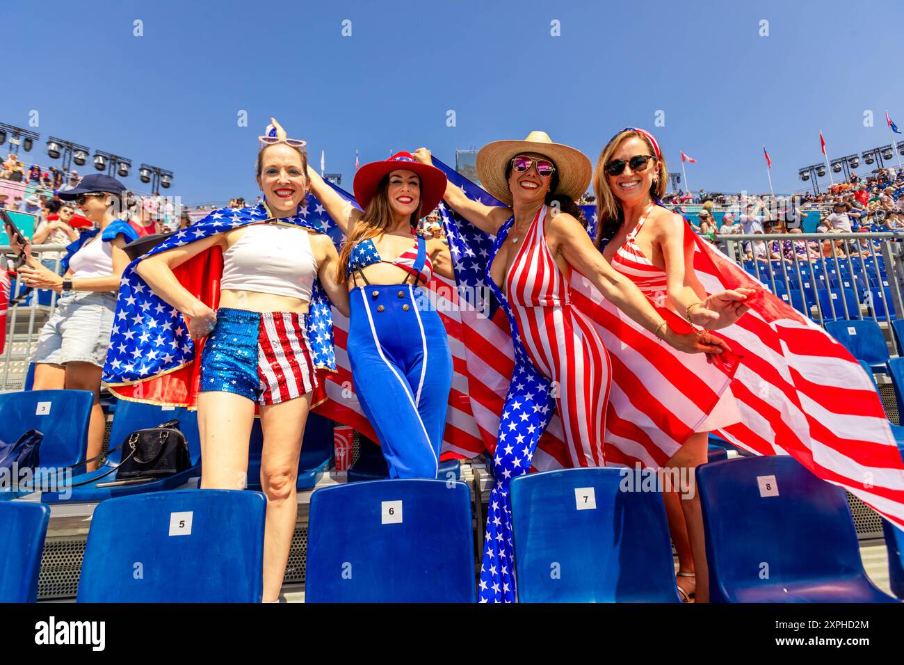 Patriotic American Woman jumping and cheering for Team USA and the Paris 2024 Olympics in front of the Eiffel Tower, Paris, France, Europe Copyright: Stock Photo
