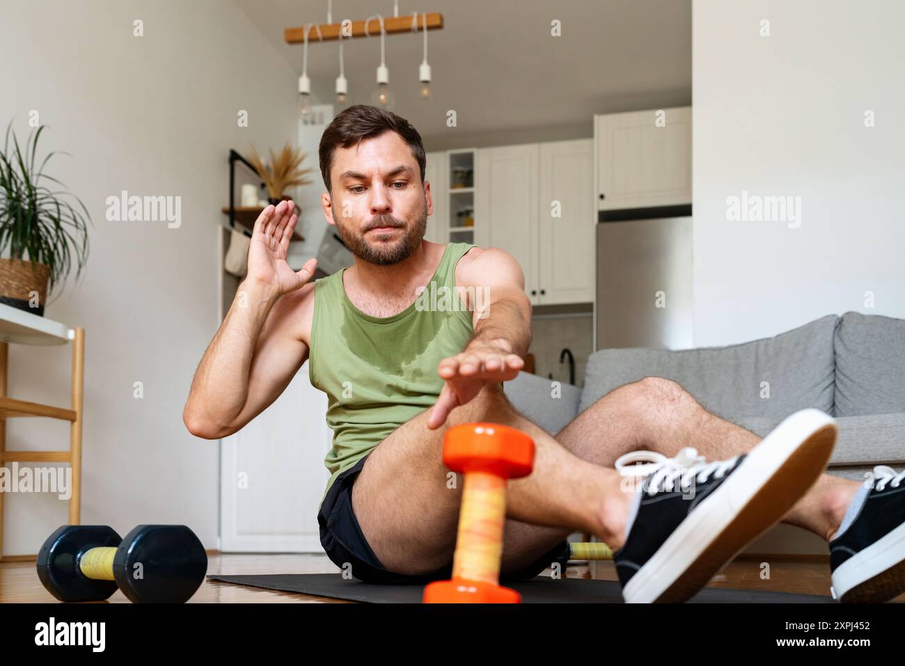 Caucasian man doing home workout, ab exercise. Stock Photo