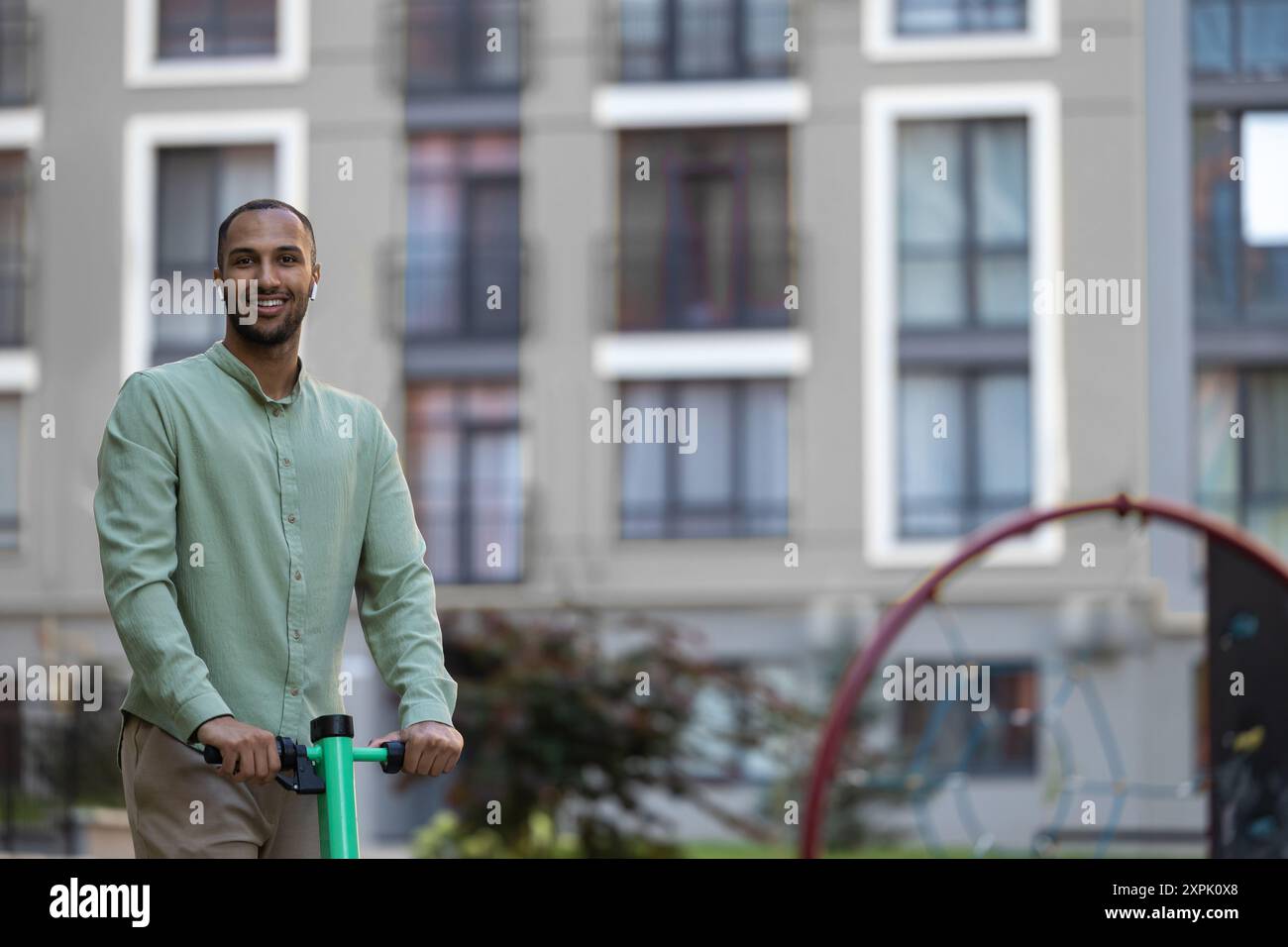 Black man using ecological mean of transportation while resting on city