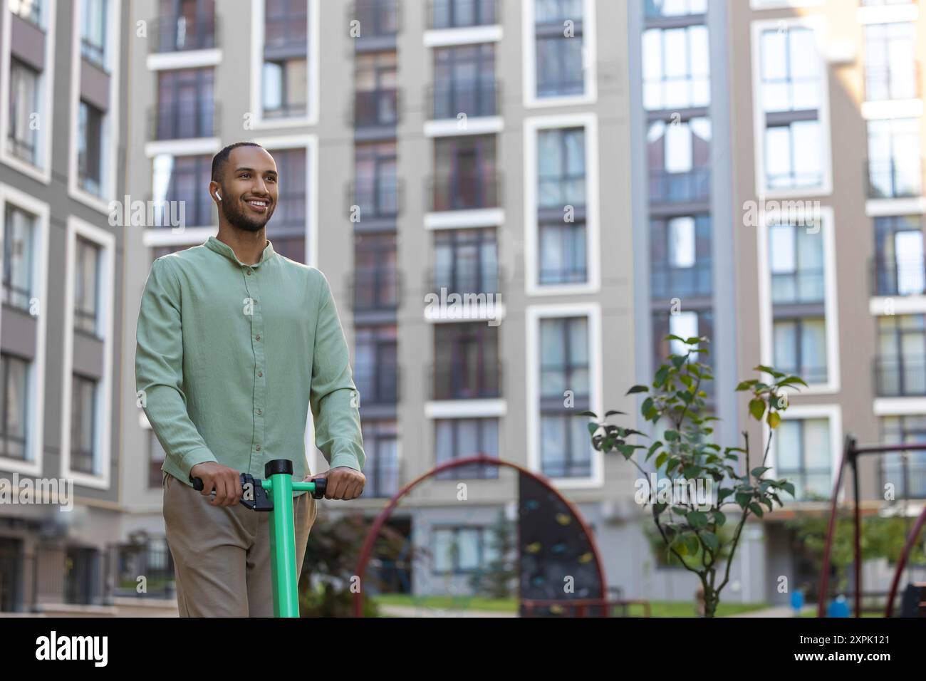 Black man using ecological mean of transportation while resting on city