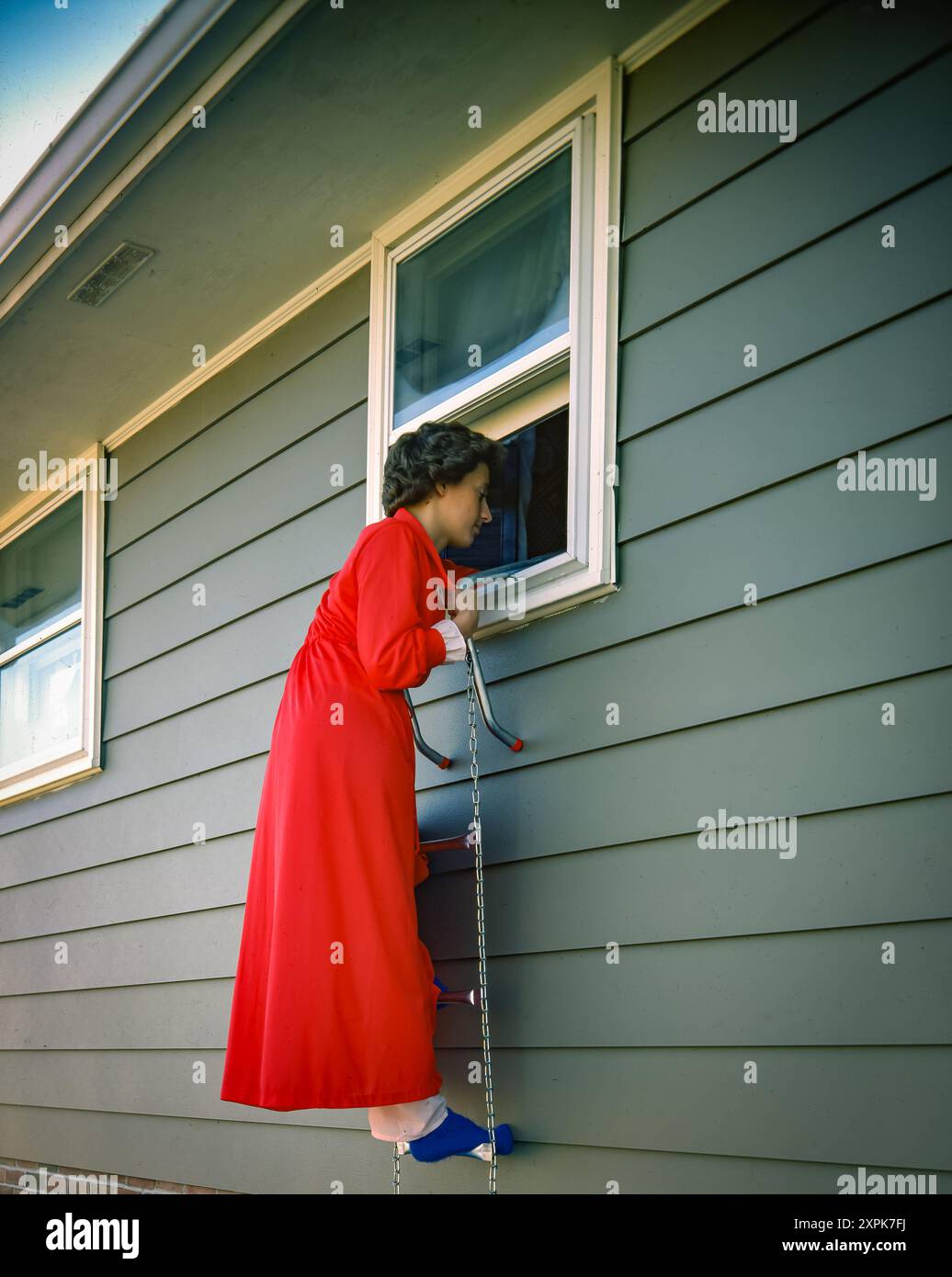 lady climbs through window and dress falls down Woman climbing out of house as smoke billows from inside, depicting emergency escape during house fire urgent residential safety situation Stock Photo SLEEVES_Cap Sleeve