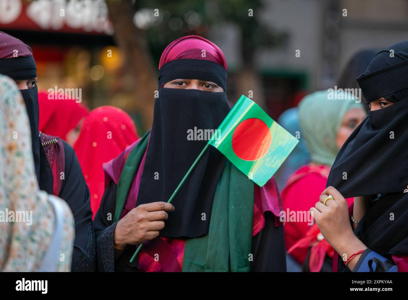 Madrid, Spain. 06th Aug, 2024. A woman carries a flag during a rally. The Bangladeshi community living in Spain, represented and convened in Madrid by the organization 'Valiente Bangla', celebrated in Lavapies Square the resignation of Prime Minister Sheikh Hasina and supported the students protesting in Bangladesh against government corruption. Credit: SOPA Images Limited/Alamy Live News Stock Photo