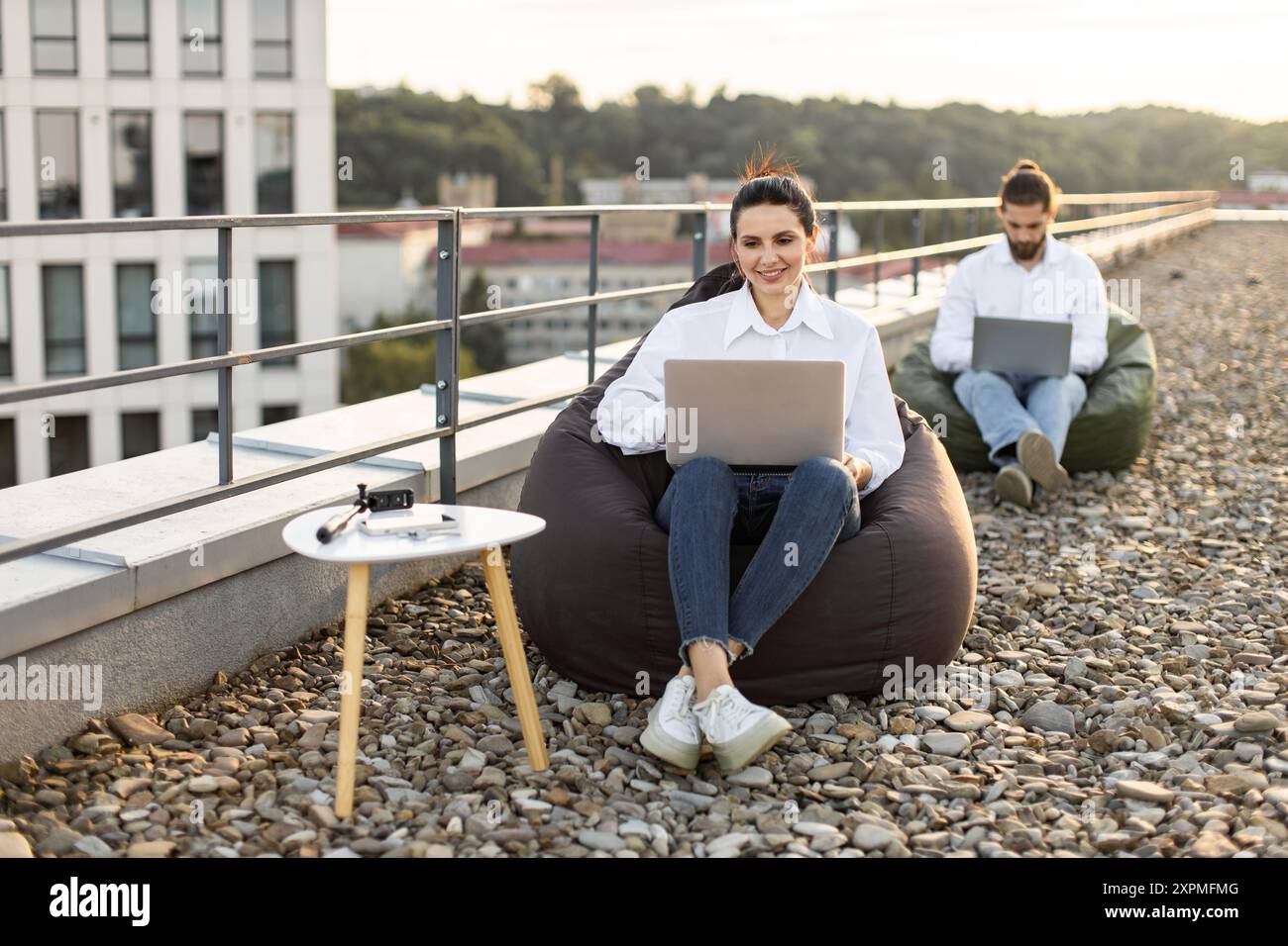 Outdoor workspace with professionals working on laptops Stock Photo