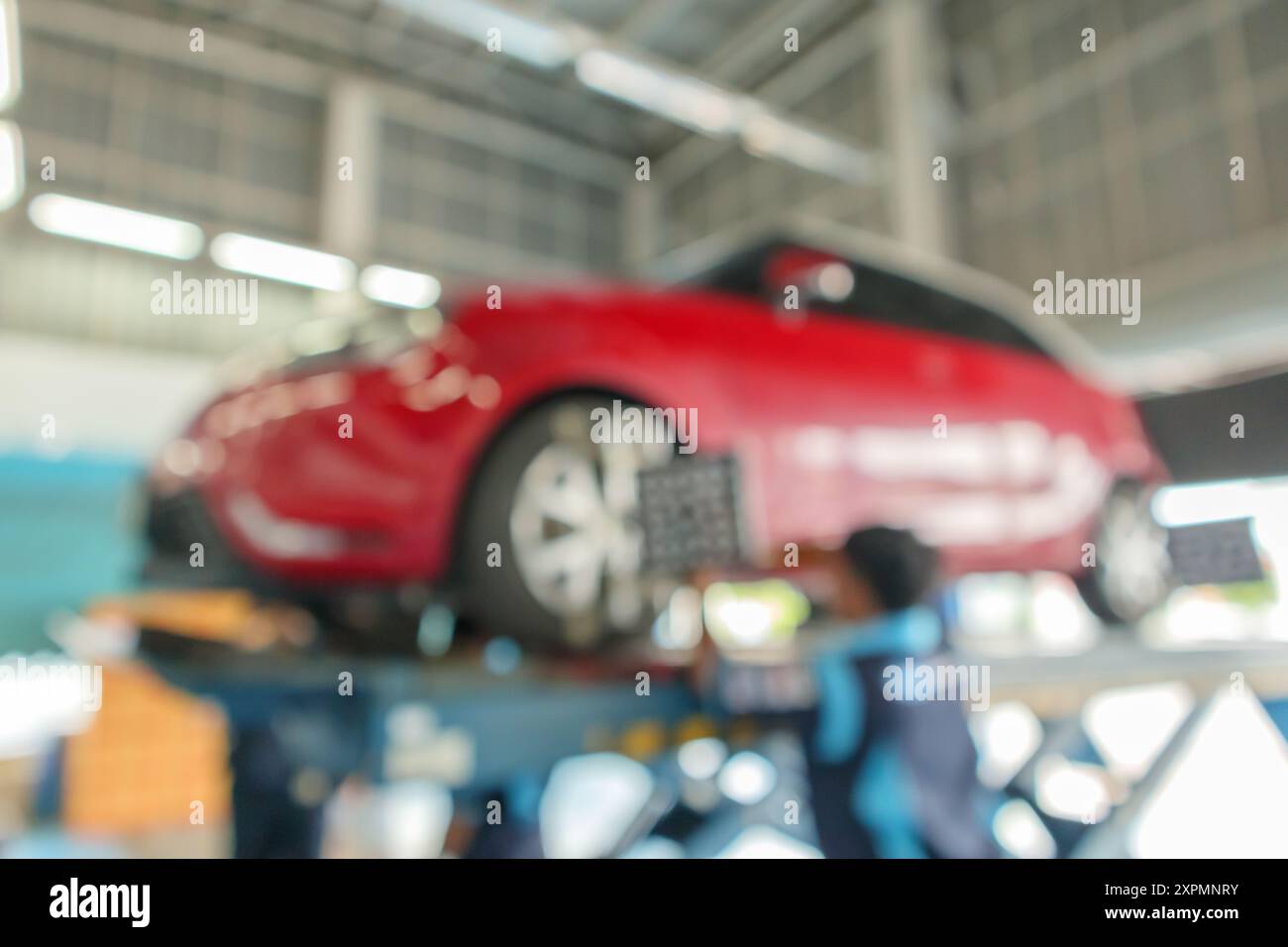 Abstract blur red car wheel alignment in progress at auto repair service centre background Stock Photo