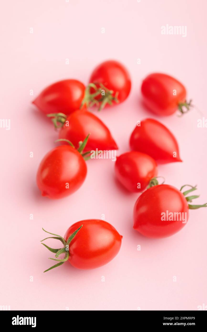 Red cherry tomatoes on a pink background. Stock Photo