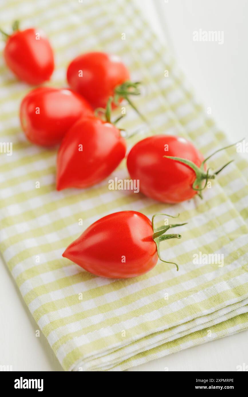 Red cherry tomatoes on a checkered napkin. Stock Photo