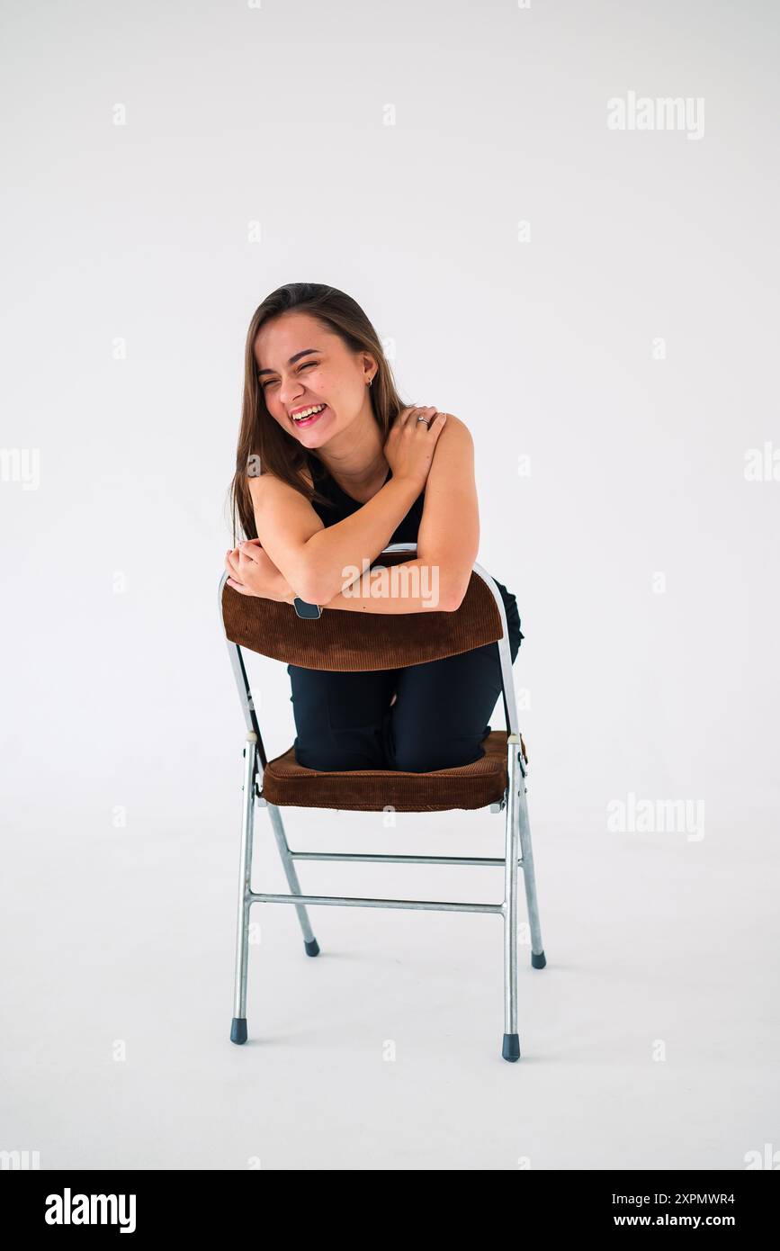 girl sitting on a chair and smiling Stock Photo - Alamy