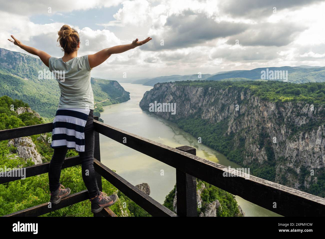 the-girl-stands-with-her-arms-outstretched-at-the-ploce-viewpoint-on