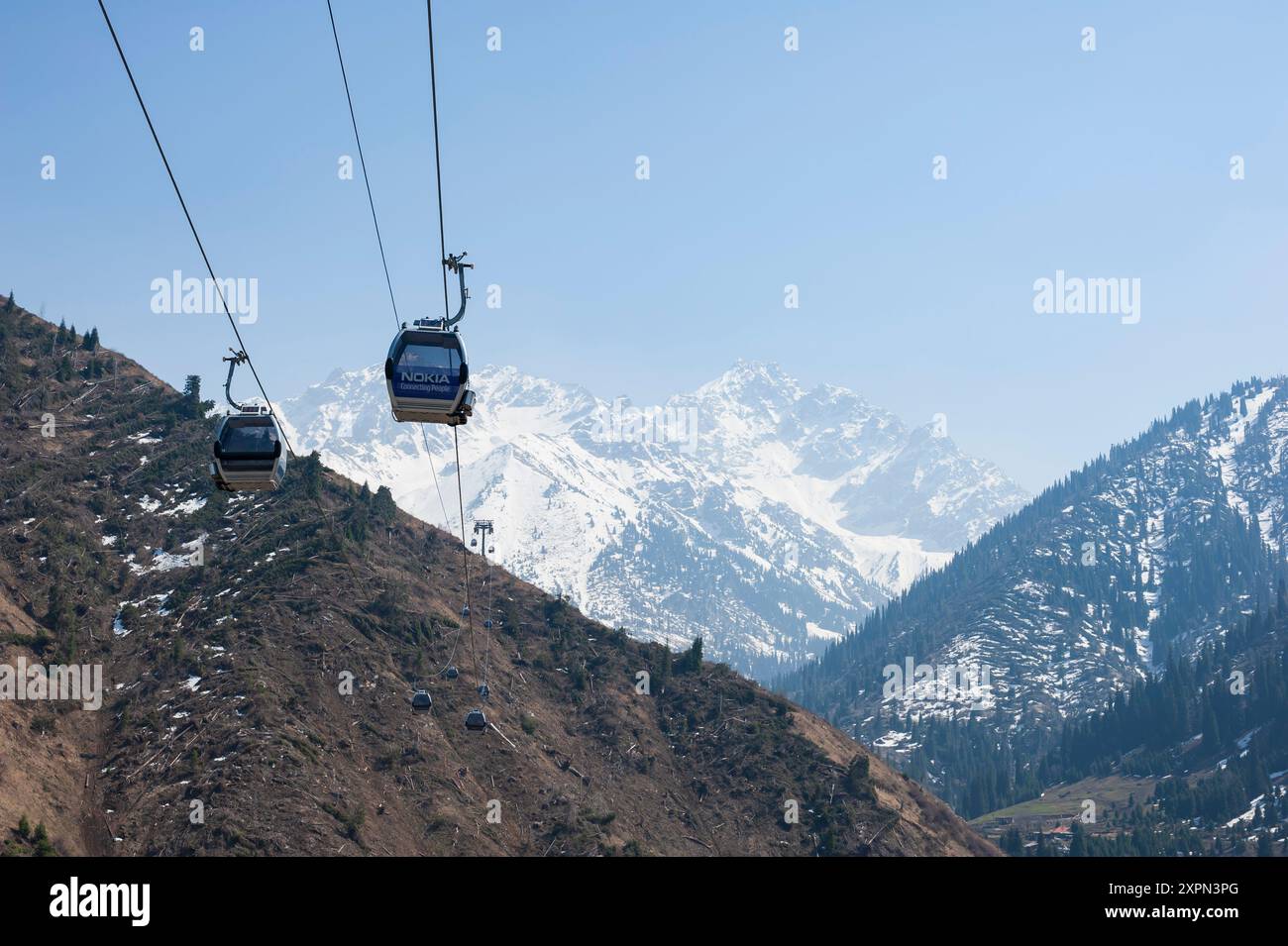 Kazakhstan, Almaty, April 18th, 2012. Cable car passing above a mountain valley, Medeu Valley, or the valley of Malaya Almatinka River Stock Photo