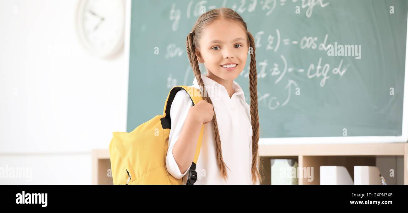 Cute little schoolgirl in classroom Stock Photo - Alamy