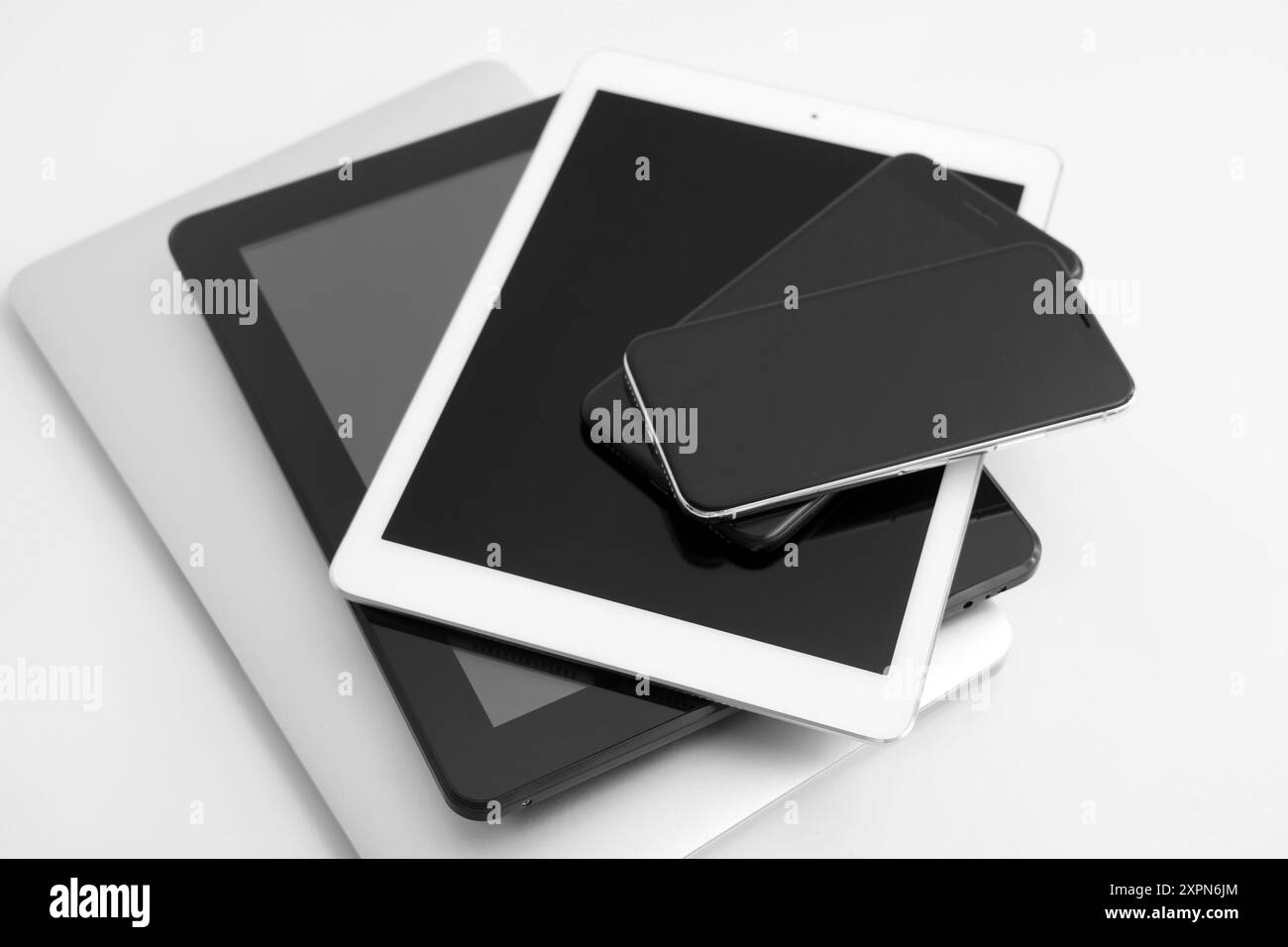 Stack of different modern gadgets on light background Stock Photo